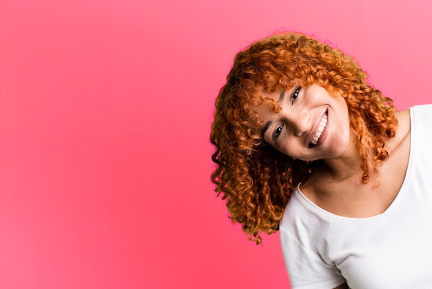 Mulher bonita de cabelo ruivo com um espaço de cópia ao lado apresentando algo