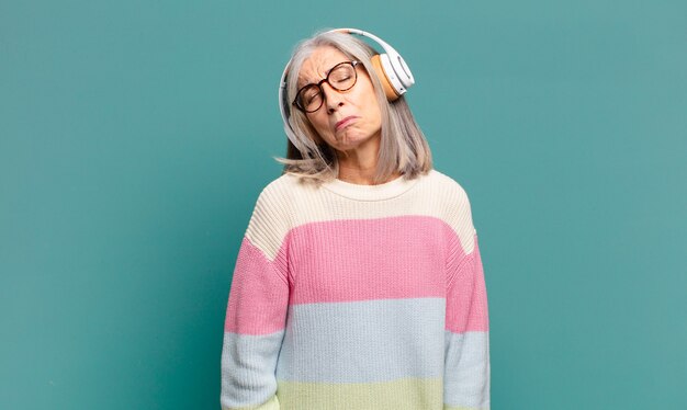 Mulher bonita de cabelos grisalhos ouvindo música com fones de ouvido