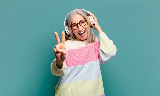 Mulher bonita de cabelos grisalhos ouvindo música com fones de ouvido