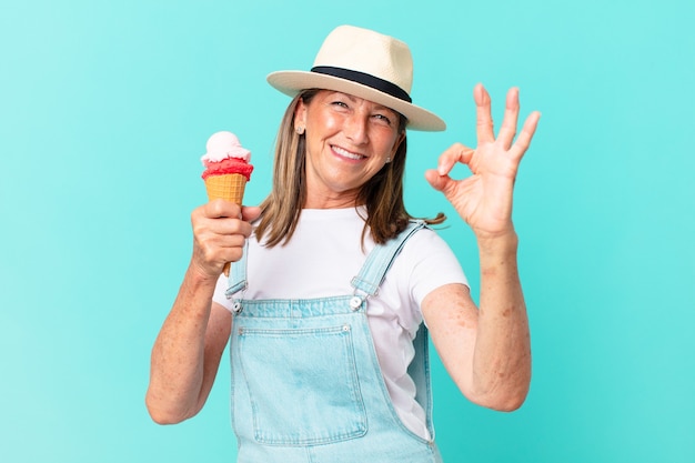 Mulher bonita de meia-idade com chapéu e segurando um sorvete. conceito de verão