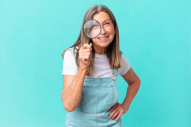 Mulher bonita de meia-idade com uma lupa. conceito de pesquisa