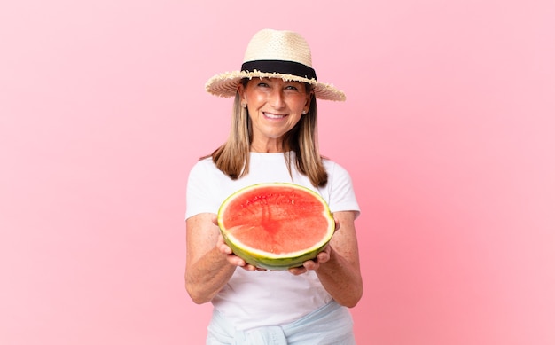 Foto mulher bonita de meia-idade com uma melancia. conceito de verão