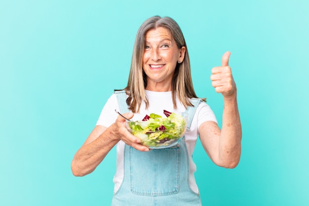 Mulher bonita de meia-idade com uma salada.