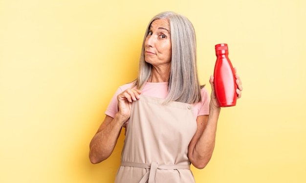 Mulher bonita de meia-idade olhando arrogante, bem sucedida, positiva e orgulhosa. conceito de ketchup