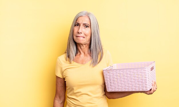 Mulher bonita de meia-idade parecendo perplexa e confusa. conceito de cesta vazia