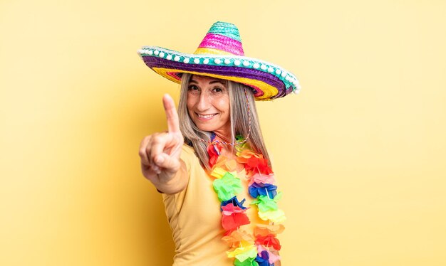 Mulher bonita de meia-idade, sorrindo e parecendo amigável, mostrando o número um. conceito de festa mexicana