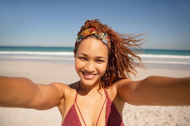 Foto mulher bonita de pé na praia