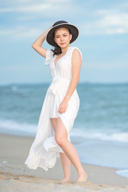 Mulher bonita de vestido branco na praia