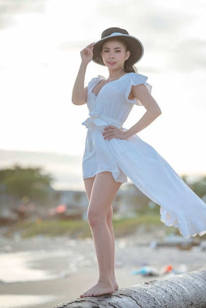 Mulher bonita de vestido branco na praia