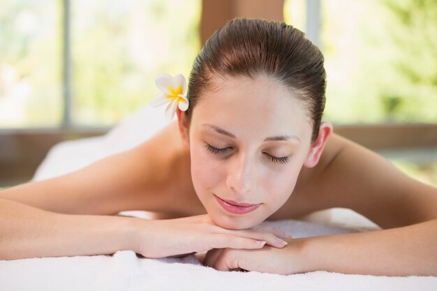 Mulher bonita deitada na mesa de massagem no centro de spa