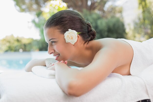 Mulher bonita deitada na mesa de massagem no centro de spa