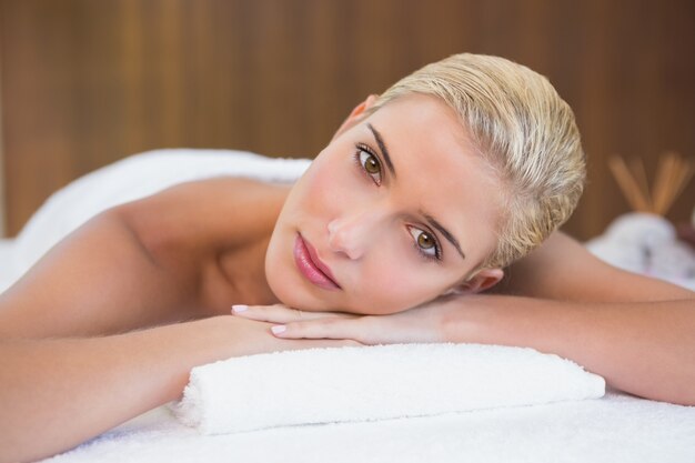 Mulher bonita deitada na mesa de massagem no centro de spa