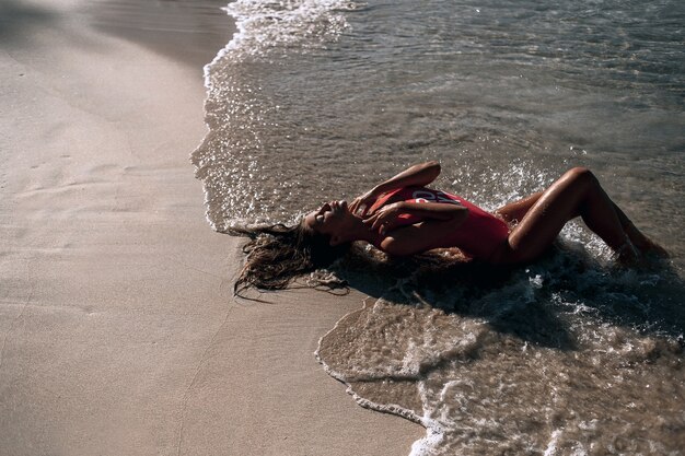 Mulher bonita deitada perto da praia