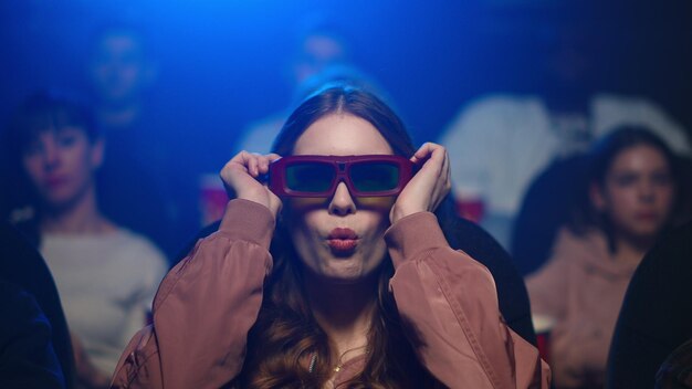 Mulher bonita desfrutando de comédia no cinema Menina sorridente colocando óculos 3d