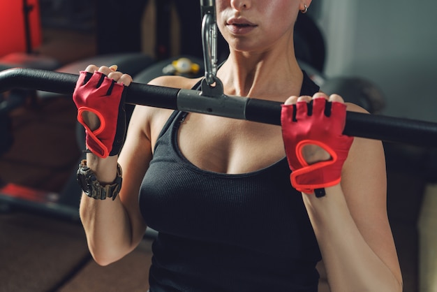 Mulher bonita do ajuste muscular que exercita os músculos do edifício