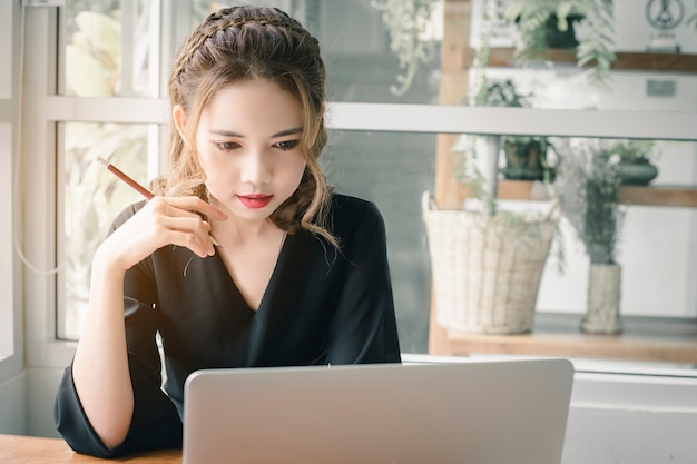 Mulher bonita do Freelancer que trabalha em linha em sua casa.