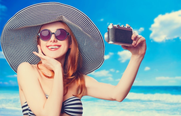 Mulher bonita do ruivo que faz o selfie em uma praia.