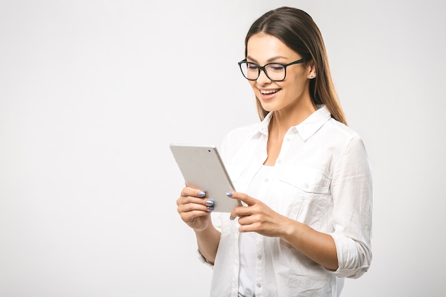 Mulher bonita e confiante na moda com uma camisa clássica e um tablet nas mãos