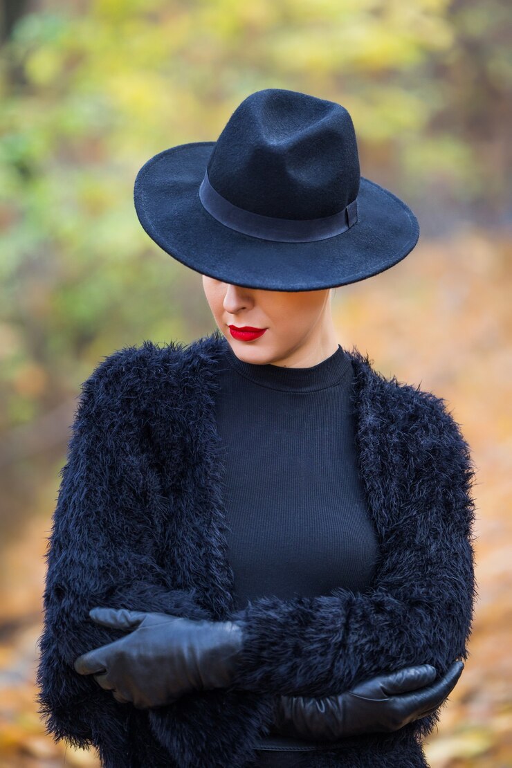 Foto mulher bonita e elegante com um chapéu preto no outono park