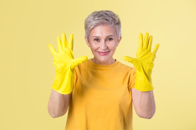 Mulher bonita e elegante com uma camiseta amarela e luvas de borracha