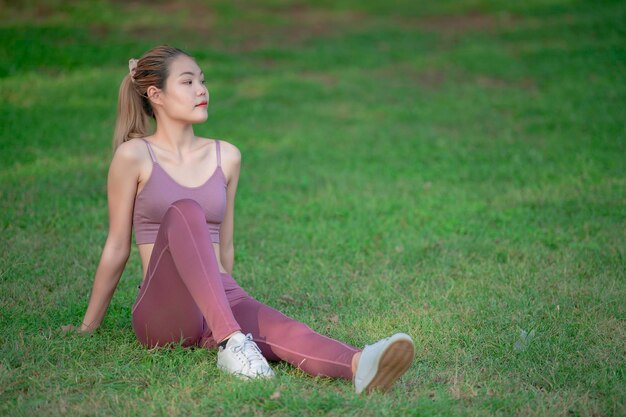 Mulher bonita e magra asiática no parqueUma jovem adora exercícios saudáveisAdolescente usa roupas esportivas
