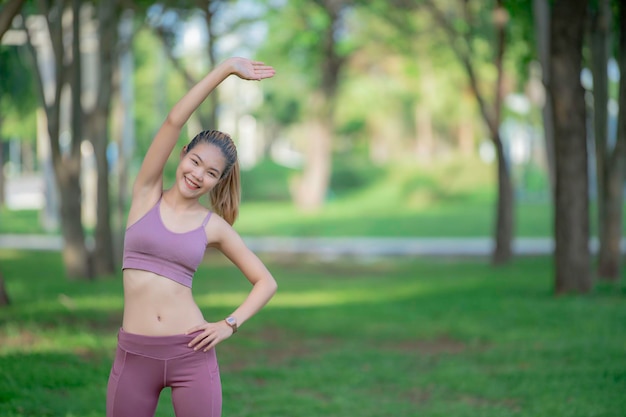 Mulher bonita e magra asiática no parqueUma jovem adora exercícios saudáveisAdolescente usa roupas esportivas