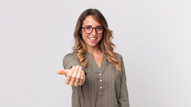 Mulher bonita e magra se sentindo feliz, bem-sucedida e confiante, enfrentando um desafio e dizendo "mande isso em frente"! ou dando as boas-vindas a você