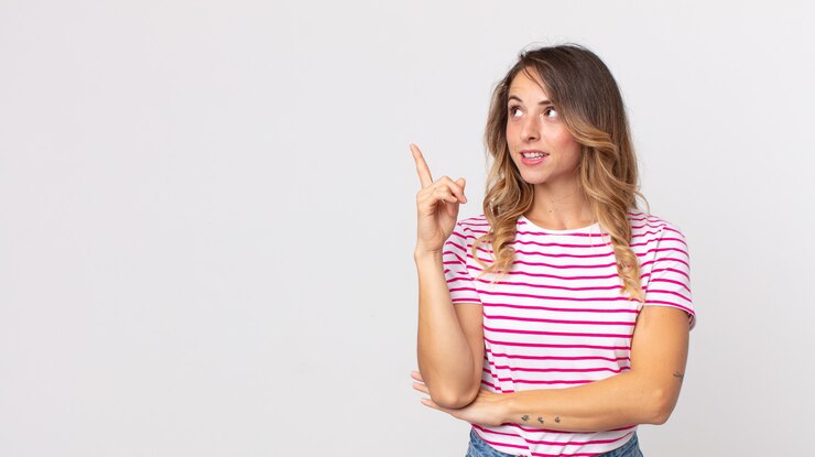 Foto mulher bonita e magra sorrindo feliz e olhando de soslaio, pensando, pensando ou tendo uma ideia