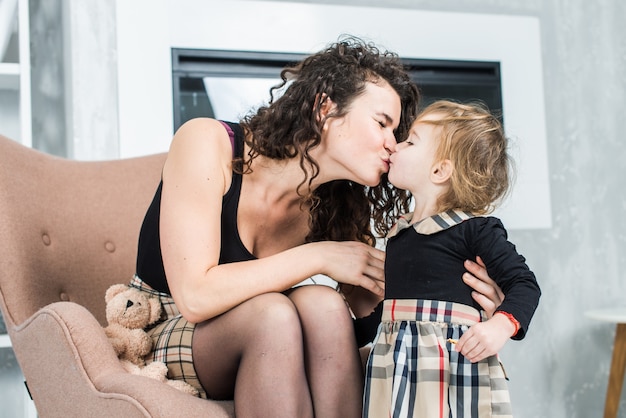 Mulher bonita e sua linda filha pequena estão soprando bolhas de sabão