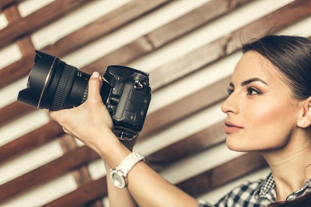 Mulher bonita é um fotógrafo profissional com câmera dslr