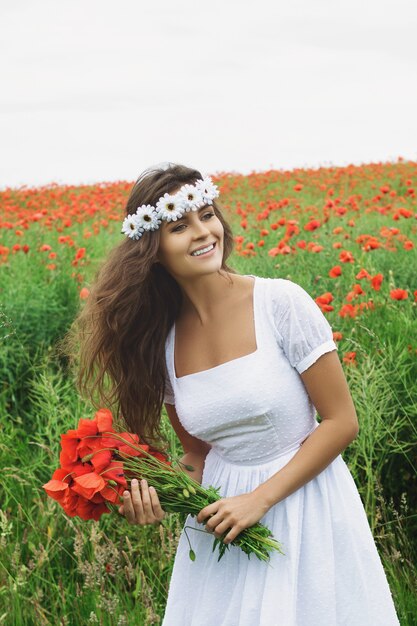 Mulher bonita em campo com muitas flores de papoula