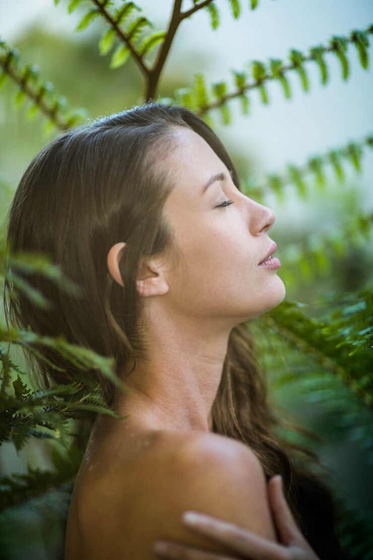 Foto mulher bonita em pé ao ar livre contra plantas verdes