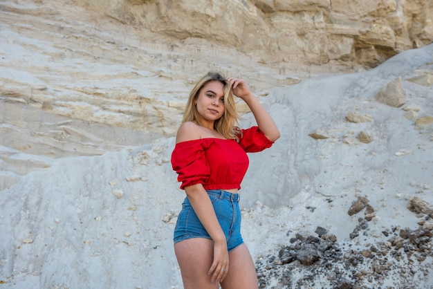 Mulher bonita em poses de roupas casuais em cânion de areia, relaxe na natureza no verão. estilo de vida