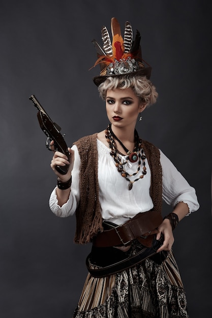 Mulher bonita em traje estilo steampunk com chapéu e arma