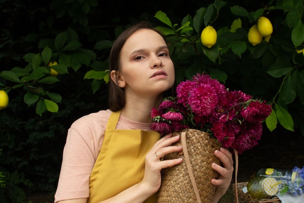 Foto mulher bonita em um avental segurando flores