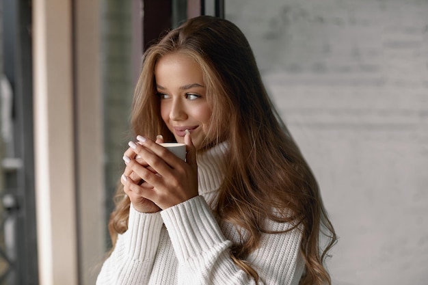 Mulher bonita em um café tomando café e sorrindo