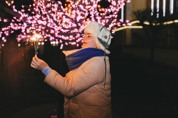 Mulher bonita em um chapéu de malha e lenço em pé na cidade com um diamante. Conceito de celebração e Natal.