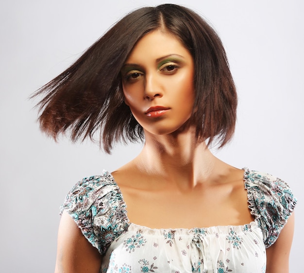 Mulher bonita em um estúdio de vestido elegante