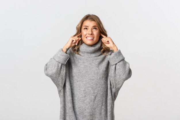 Mulher bonita em um suéter cinza posando