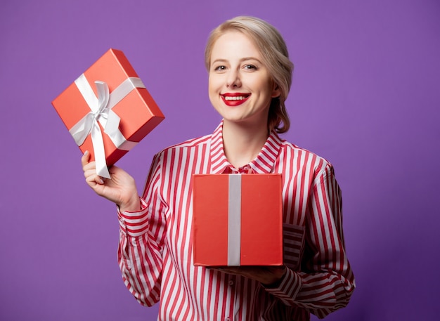 Mulher bonita em uma camisa listrada vermelha com caixa de presente