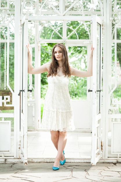 Mulher bonita em vestido rendado branco no pavilhão de verão