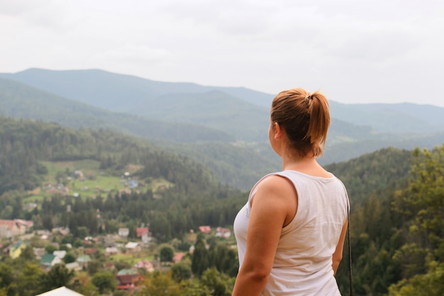 Mulher bonita entre a natureza. Relaxamento nas colinas e florestas. No alto das montanhas.