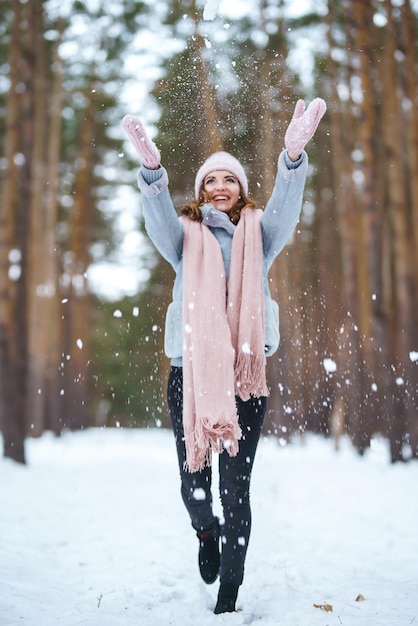 Mulher bonita está brincando com neve na floresta Inverno estilo de vida felicidade emoções natureza Natal