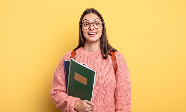 mulher bonita estudante olhando feliz e agradavelmente surpreso