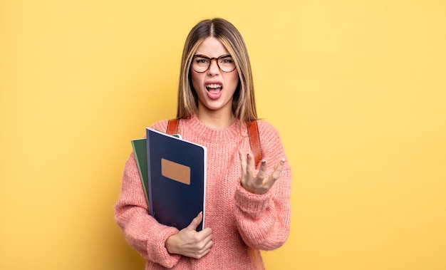 Mulher bonita estudante parecendo zangada, irritada e frustrada. livros e mochila