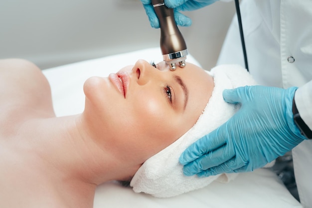 Mulher bonita fazendo tratamento facial em uma clínica de estética cosmética