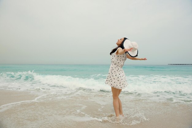 Mulher bonita feliz aproveitando as férias de verão na praia