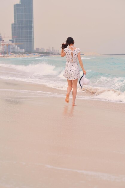 Mulher bonita feliz aproveitando as férias de verão na praia