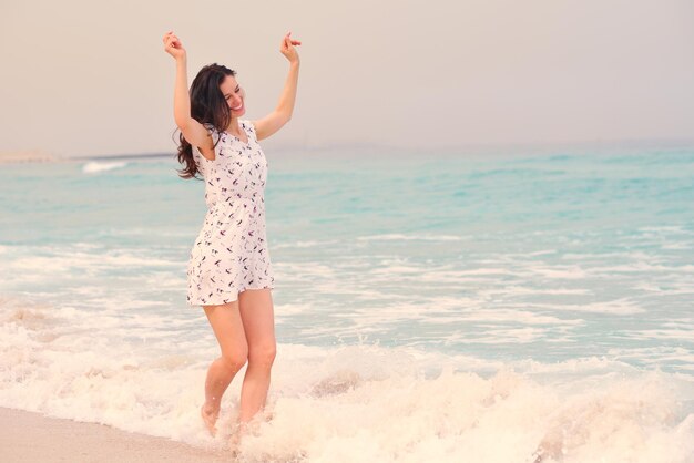 Mulher bonita feliz aproveitando as férias de verão na praia