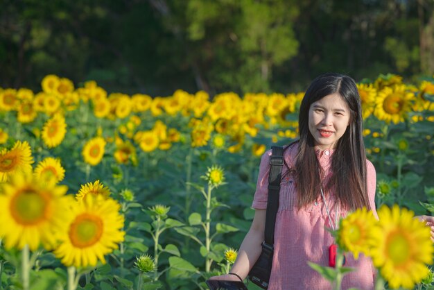 Mulher bonita feliz e desfrutar no campo de girassol